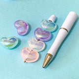 large iridescent acrylic heart beads with an aurora glow on a beaded pen base on a blue background