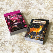 two mini sticker books in gothic forest and fairytale deer designs on a vintage patterned background
