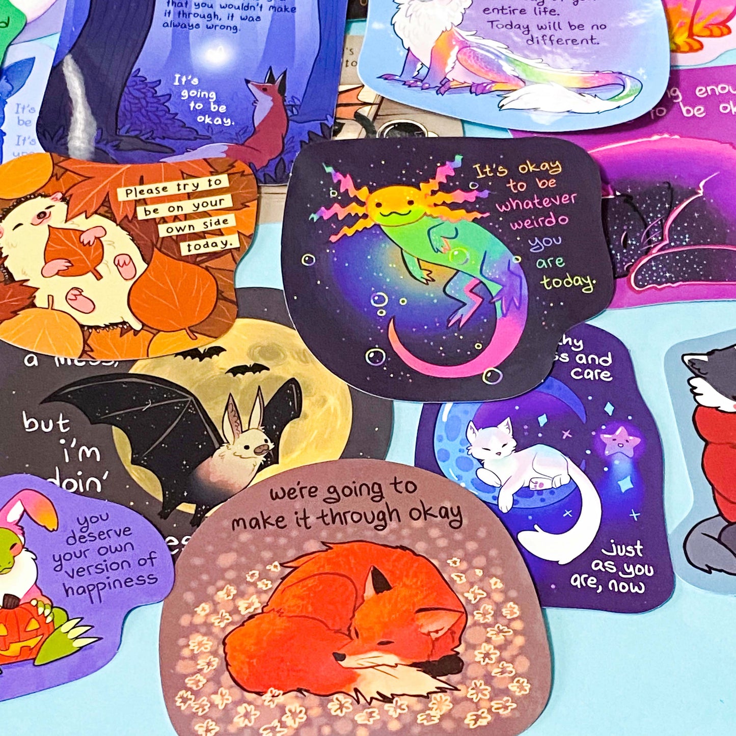 colourful glossy affirmation stickers with cute animals and positive mental health messages including axolotl hedgehog and fantasy creatures on pastel background