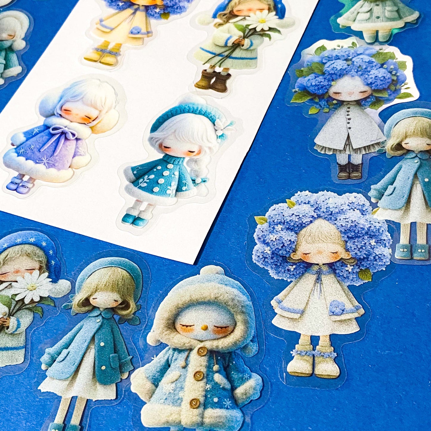 blue themed large PET doll stickers with kawaii illustrations including flowers, hydrangea, cosy winter outfits and turquoise dresses. Uk small business.