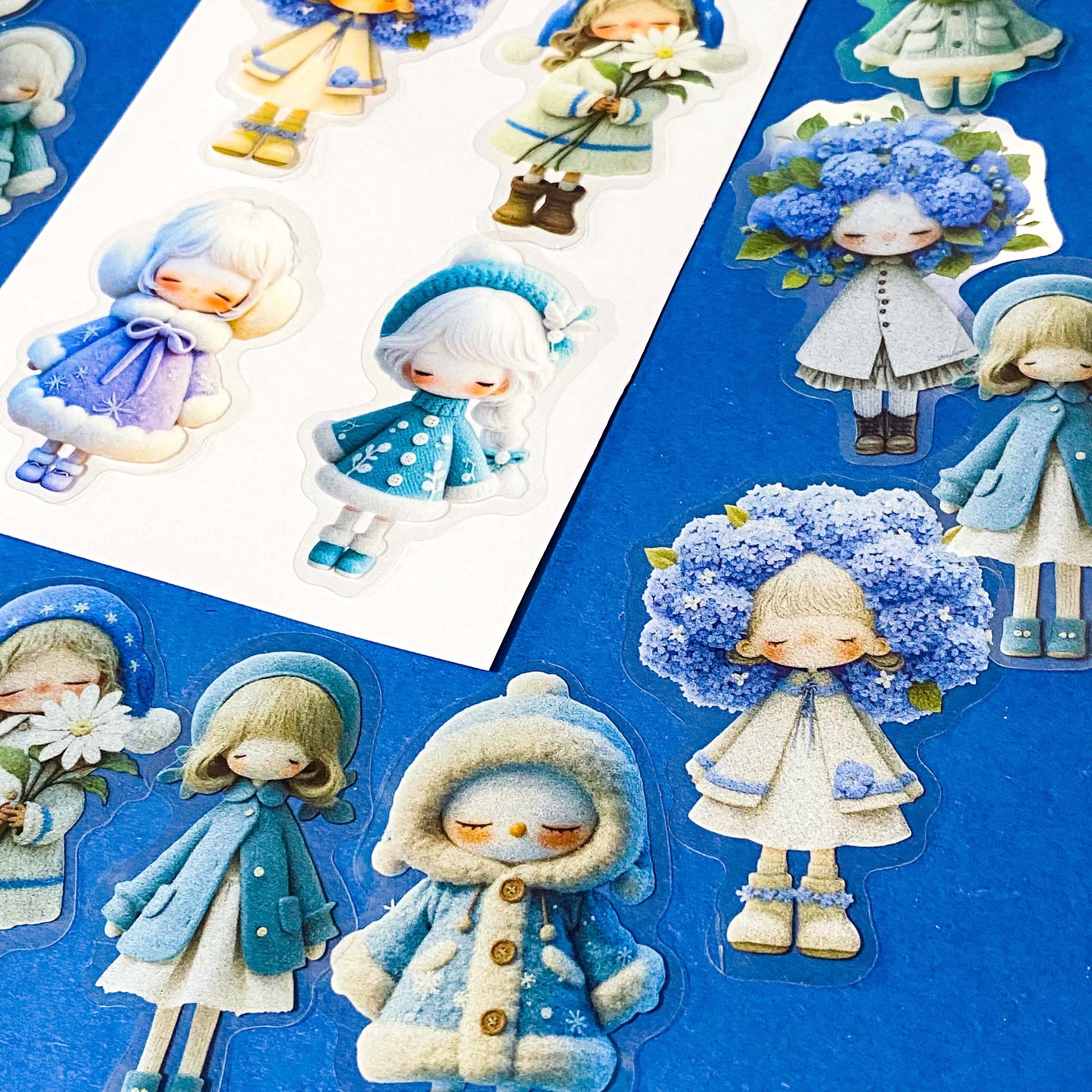 blue themed large PET doll stickers with kawaii illustrations including flowers, hydrangea, cosy winter outfits and turquoise dresses. Uk small business.