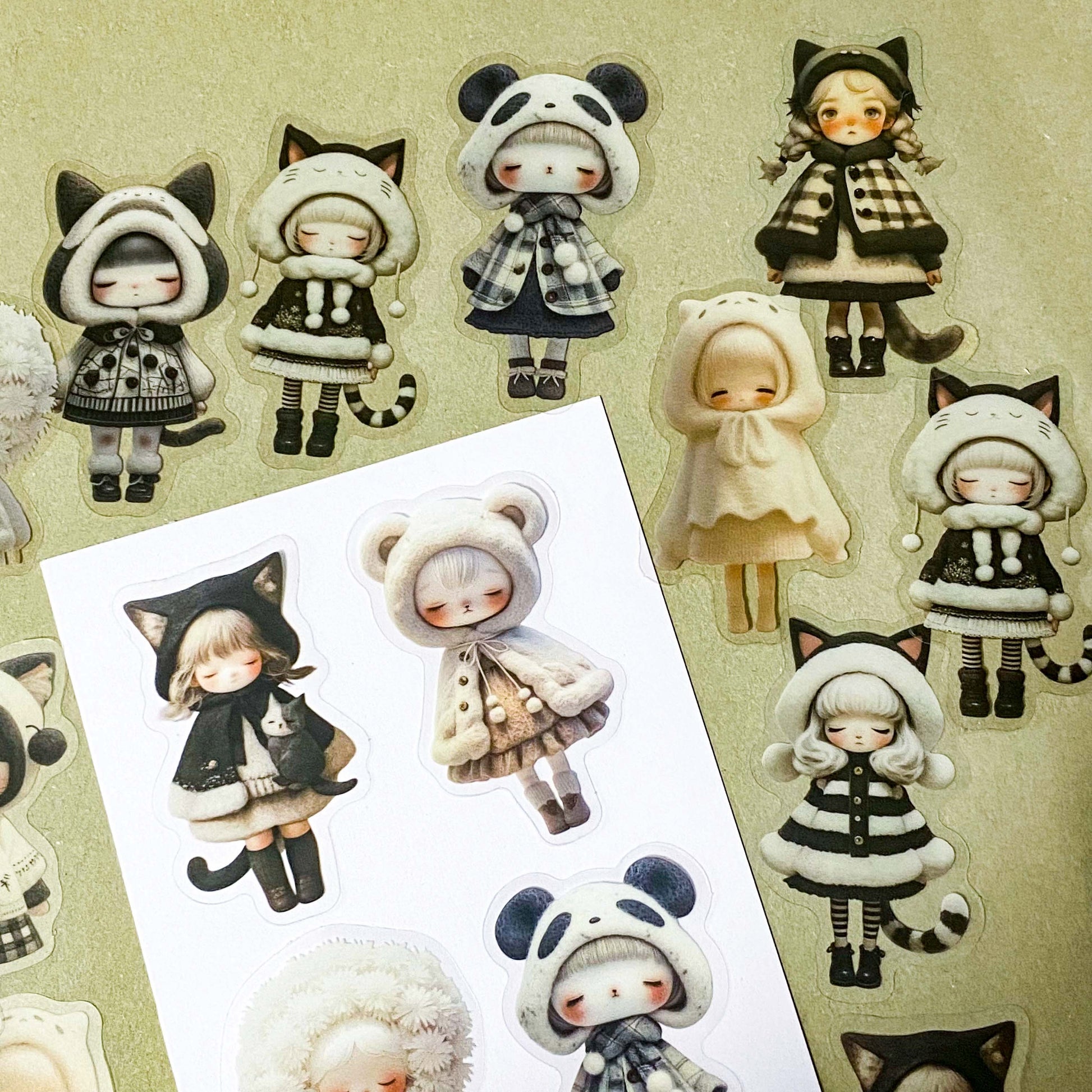 black and cream coloured large PET doll sticker set with cute animals including panda, cat and bear. Girls wearing cosy winter outfits with stripy stockings and furry hats. Uk small business selling kawaii stationery.