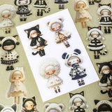 black and cream coloured large PET doll sticker set with cute animals including panda, cat and bear. Girls wearing cosy winter outfits with stripy stockings and furry hats. Uk small business selling kawaii stationery.