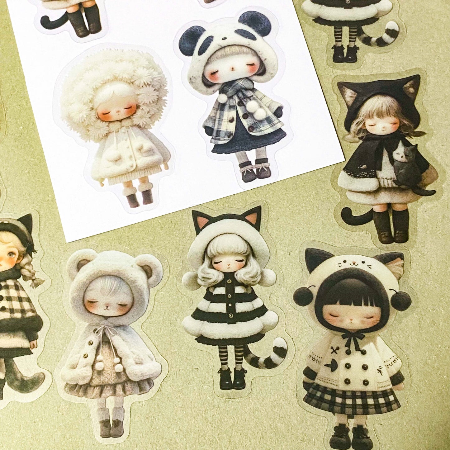 black and cream coloured large PET doll sticker set with cute animals including panda, cat and bear. Girls wearing cosy winter outfits with stripy stockings and furry hats. Uk small business selling kawaii stationery.