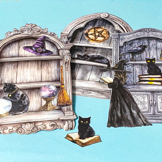 witch cabinet of curiosities ephemera pack with black cats, spell books, crystal balls and gothic shelves on blue background
