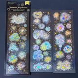 three transparent holographic firework sticker sheets with celestial stars, moons and iridescent rainbow foil effects