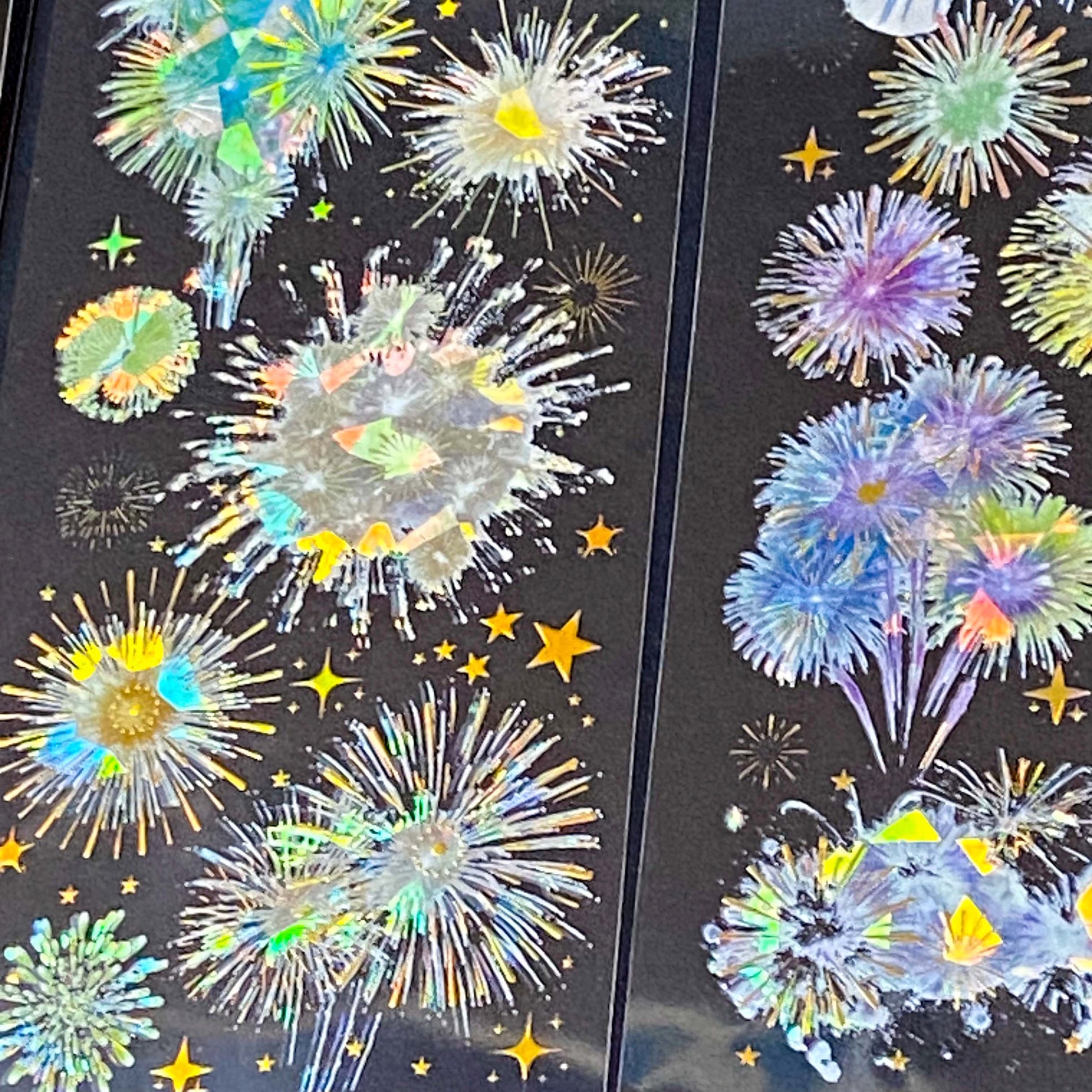 three transparent holographic firework sticker sheets with celestial stars, moons and iridescent rainbow foil effects