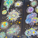 three transparent holographic firework sticker sheets with celestial stars, moons and iridescent rainbow foil effects