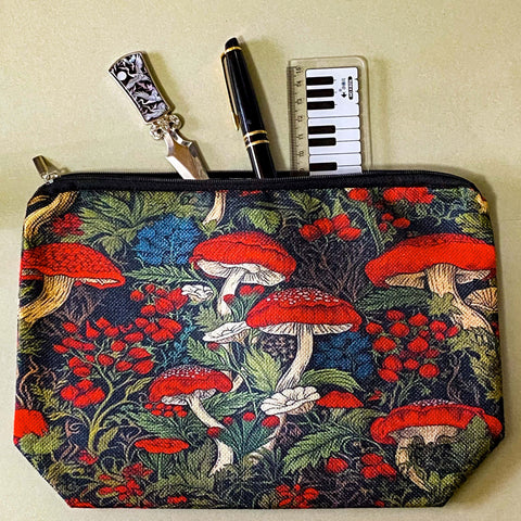 deep red canvas mushroom zip pouch featuring red toadstools, berries and botanical foliage on a dark forest background. Uk gift shop for letterbox gifts.