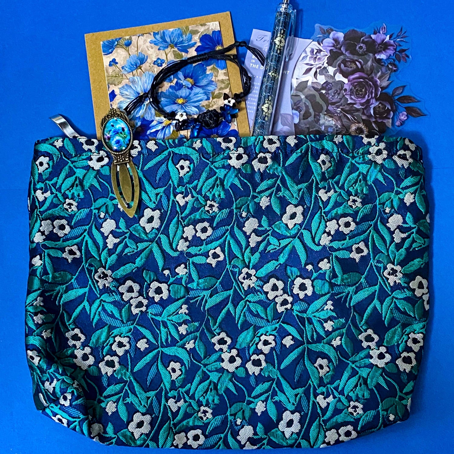 midnight petals letterbox gift set featuring a dark blue and green floral tapestry pouch, botanical ballpoint pen, blank flower greetings card and envelope, floral crystal and butterfly bracelet and dark floral clear sticker pack. uk cute and beautiful gift shop.