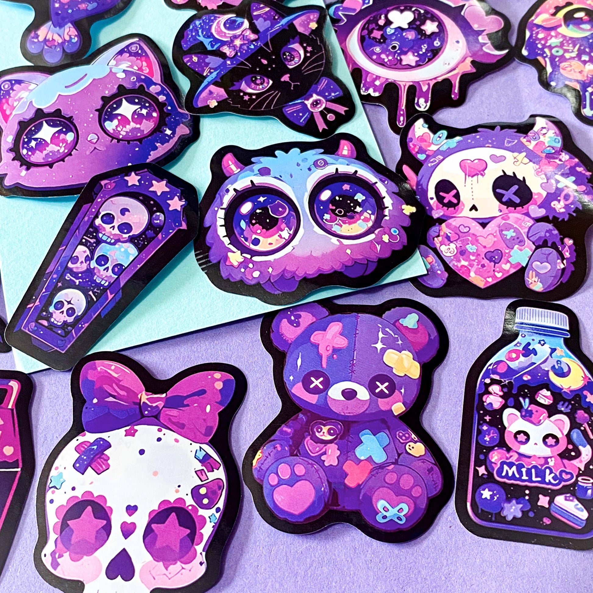 pack of 50 large glossy laptop stickers featuring bats, skulls, moons, owls, eyes, cows, unicorns, potion bottles, crystals, celestial artwork in purple, pink , lilac and blue tones. vibrant pack. uk cute stickers shop.