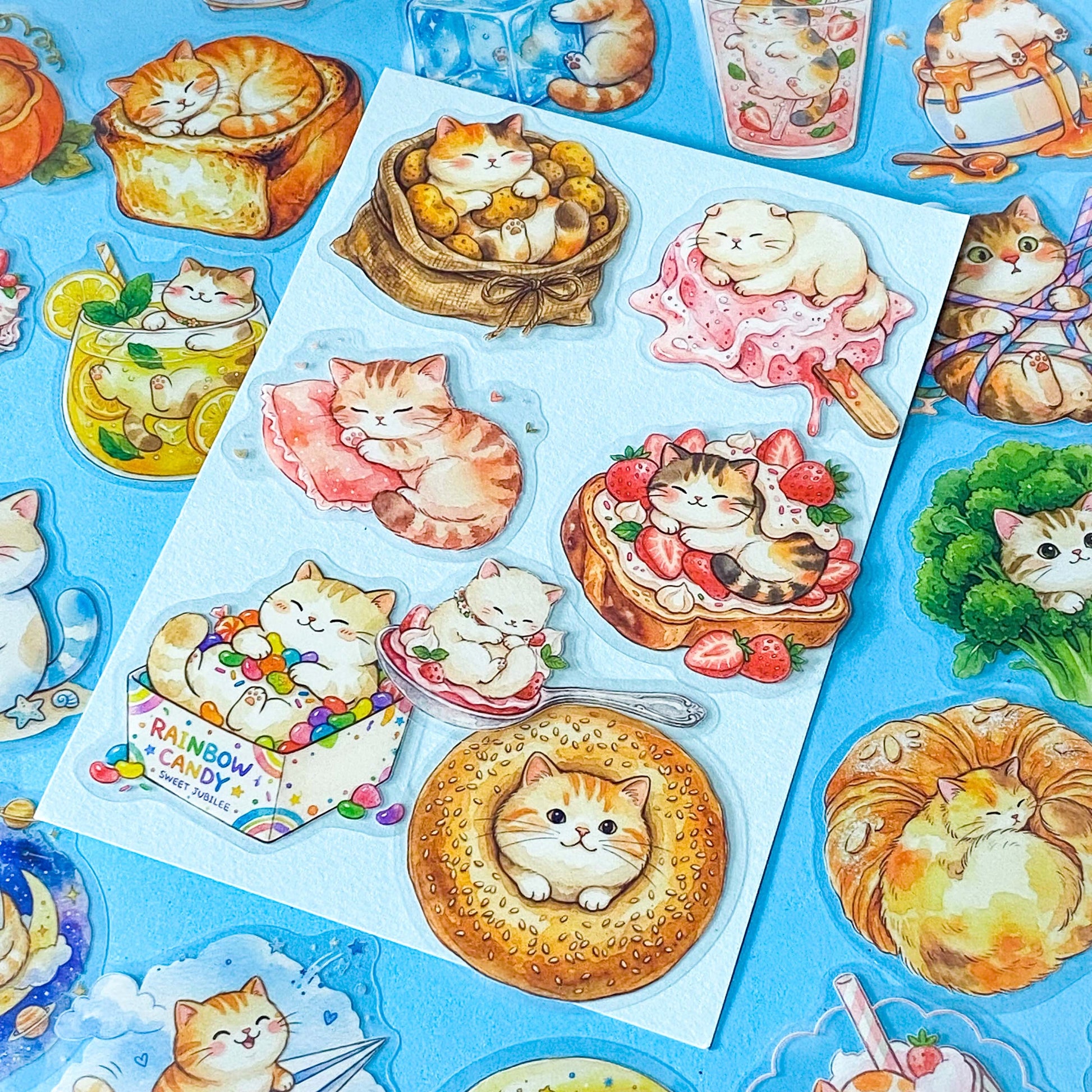 50 adorable watercolour PET cat stickers featuring sleepy kittens curled up in bread, desserts, fruit, drinks, vegetables, clouds and cosy scenes. Uk stationery gift shop.