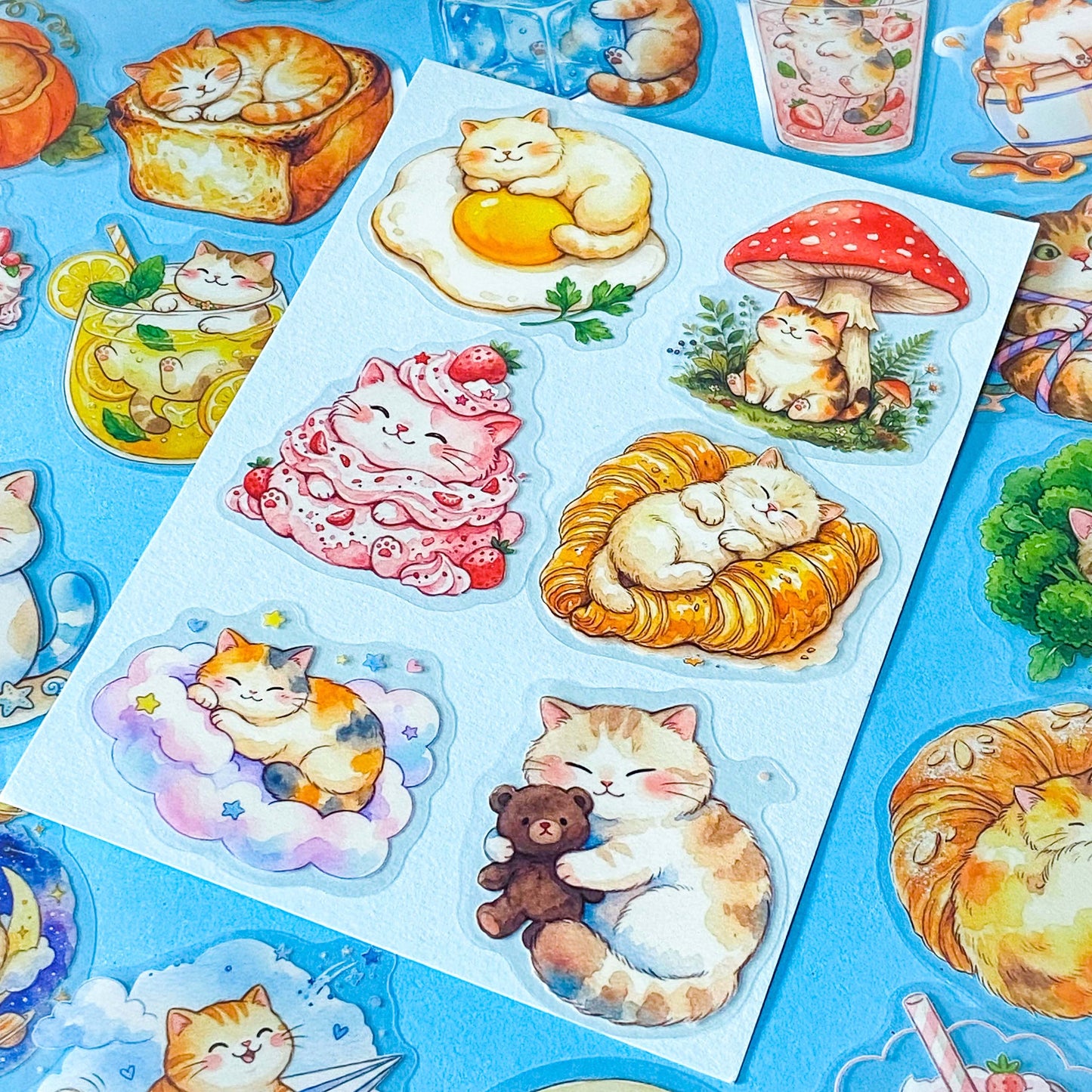 50 adorable watercolour PET cat stickers featuring sleepy kittens curled up in bread, desserts, fruit, drinks, vegetables, clouds and cosy scenes. Uk stationery gift shop.