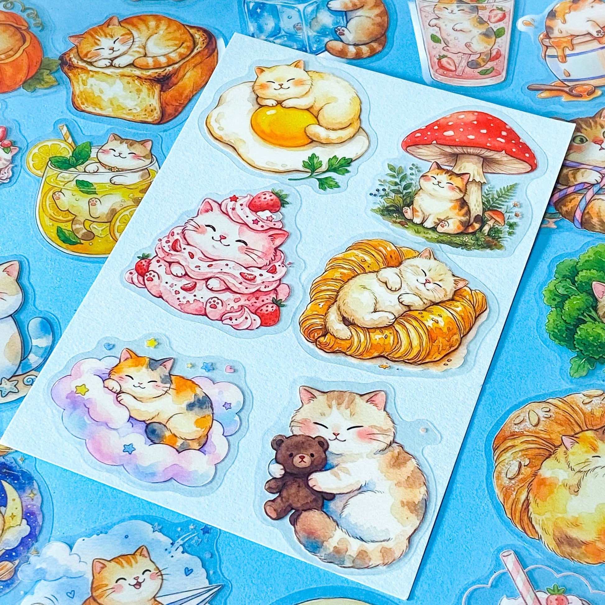 50 adorable watercolour PET cat stickers featuring sleepy kittens curled up in bread, desserts, fruit, drinks, vegetables, clouds and cosy scenes. Uk stationery gift shop.