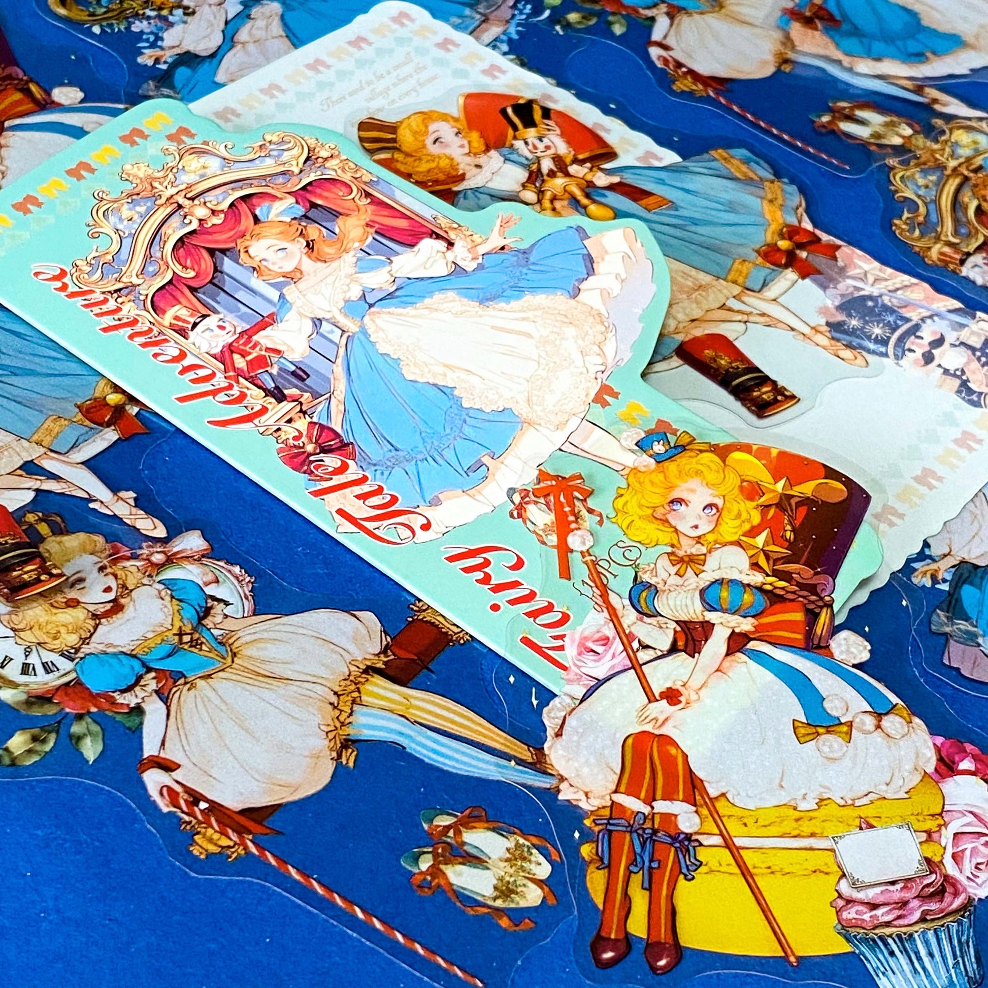 large nutcracker- inspired clear PET sticker pack featuring ballet princess illustrations, toy soldiers, ribbons, clocks and ornate storybook artwork in blue and gold tones with red.