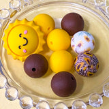 sunny yellow and dark brown silicone beads mix with sunshine jumbo 27mm focal bead and patterned sunflower design 16mm beads. uk craft supplies shop.