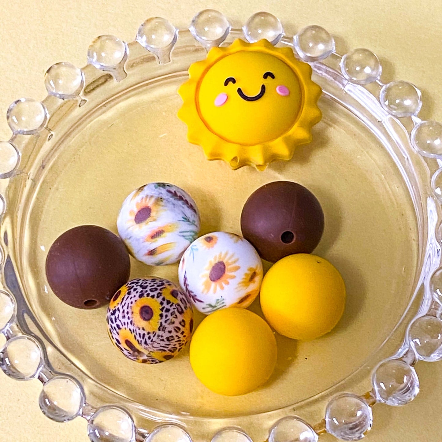 sunny yellow and dark brown silicone beads mix with sunshine jumbo 27mm focal bead and patterned sunflower design 16mm beads. uk craft supplies shop.