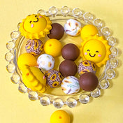 sunny yellow and dark brown silicone beads mix with sunshine jumbo 27mm focal bead and patterned sunflower design 16mm beads. uk craft supplies shop.