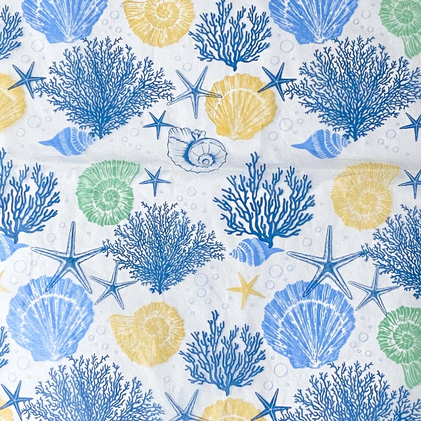 Seashell, starfish, and coral pattern tissue paper sheets on a white background