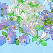 pink lilac and pearly white  flower and leaf acrylic charms on a blue background