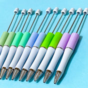 pastel beaded pen bases in sage, mint, periwinkle, lime and lavender on a blue background