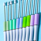 pastel beaded pen bases in sage, mint, periwinkle, lime and lavender on a blue background
