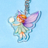 Fairy keychain with purple wings and a flower on a light blue background