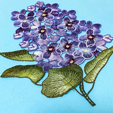 embroidered sew on very large hydrangea lilac and purple fabric applique patch on a blue background