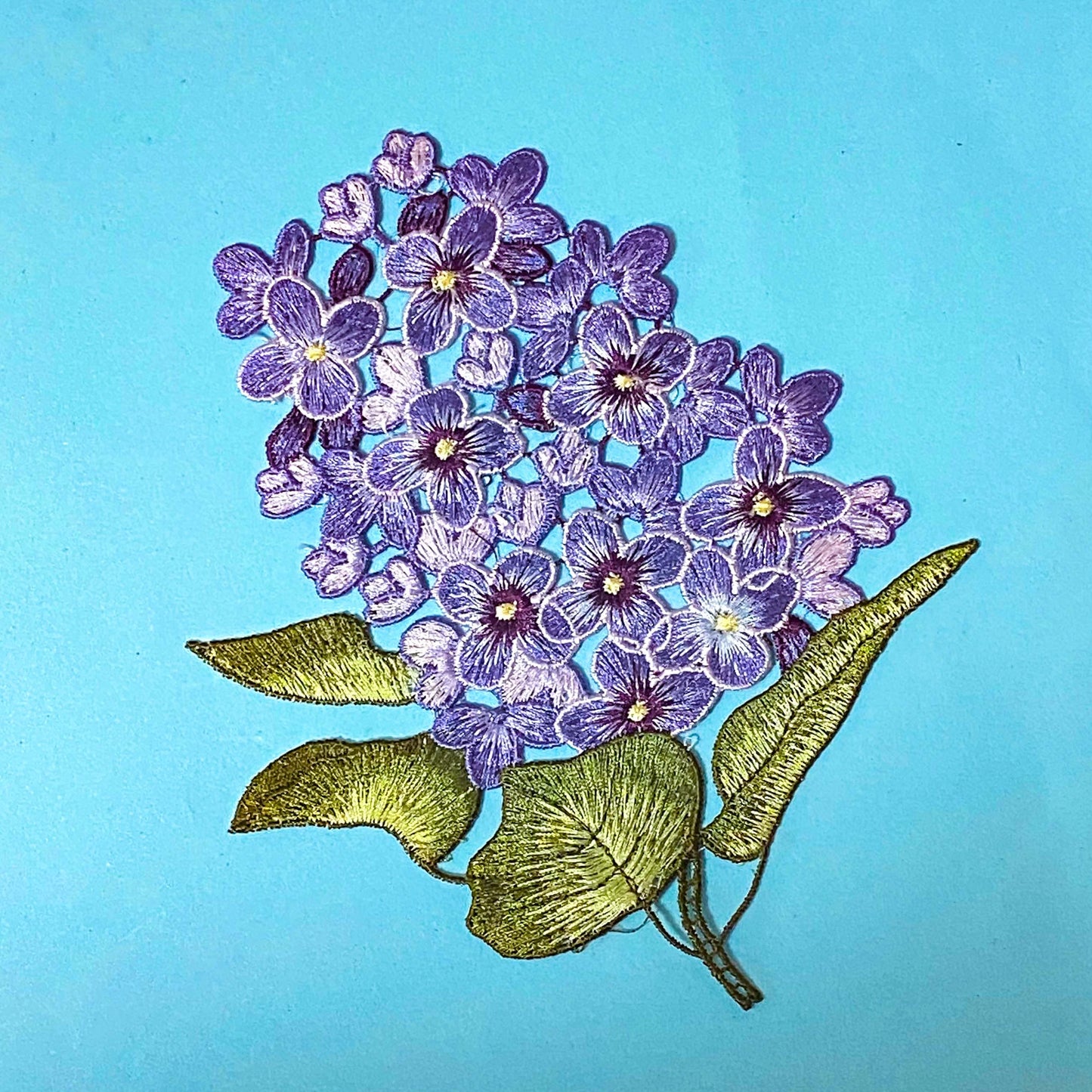 embroidered sew on very large hydrangea lilac and purple fabric applique patch on a blue background