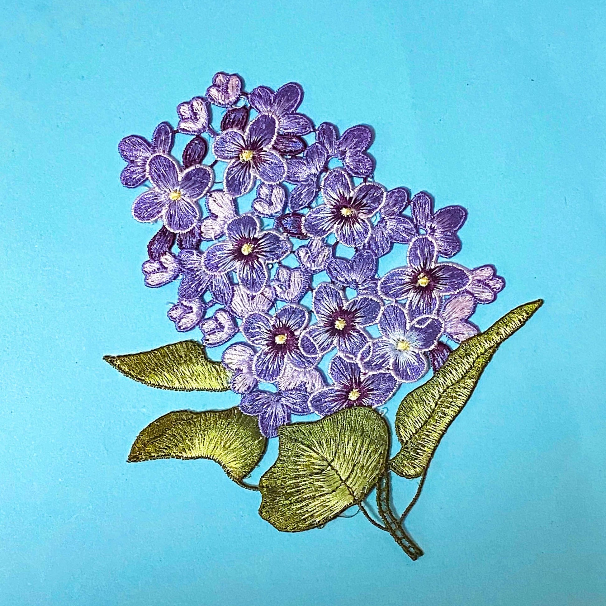 embroidered sew on very large hydrangea lilac and purple fabric applique patch on a blue background