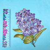embroidered sew on very large hydrangea lilac and purple fabric applique patch on a blue background