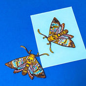 two colourful brown and teal embroidered moth patches that can be ironed on or sewn on. 