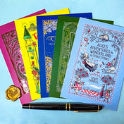 set of 5 vintage literary postcards featuring fairytale book covers including Alice in Wonderland, Wizard of Oz and Grimm Fairy Stories on a blue Background