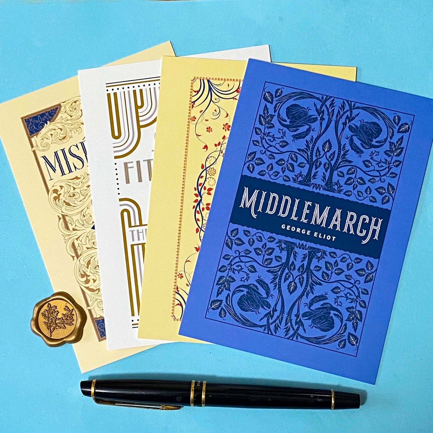 set of 4 vintage literary postcards featuring classic book covers in art deco style on a bleu background