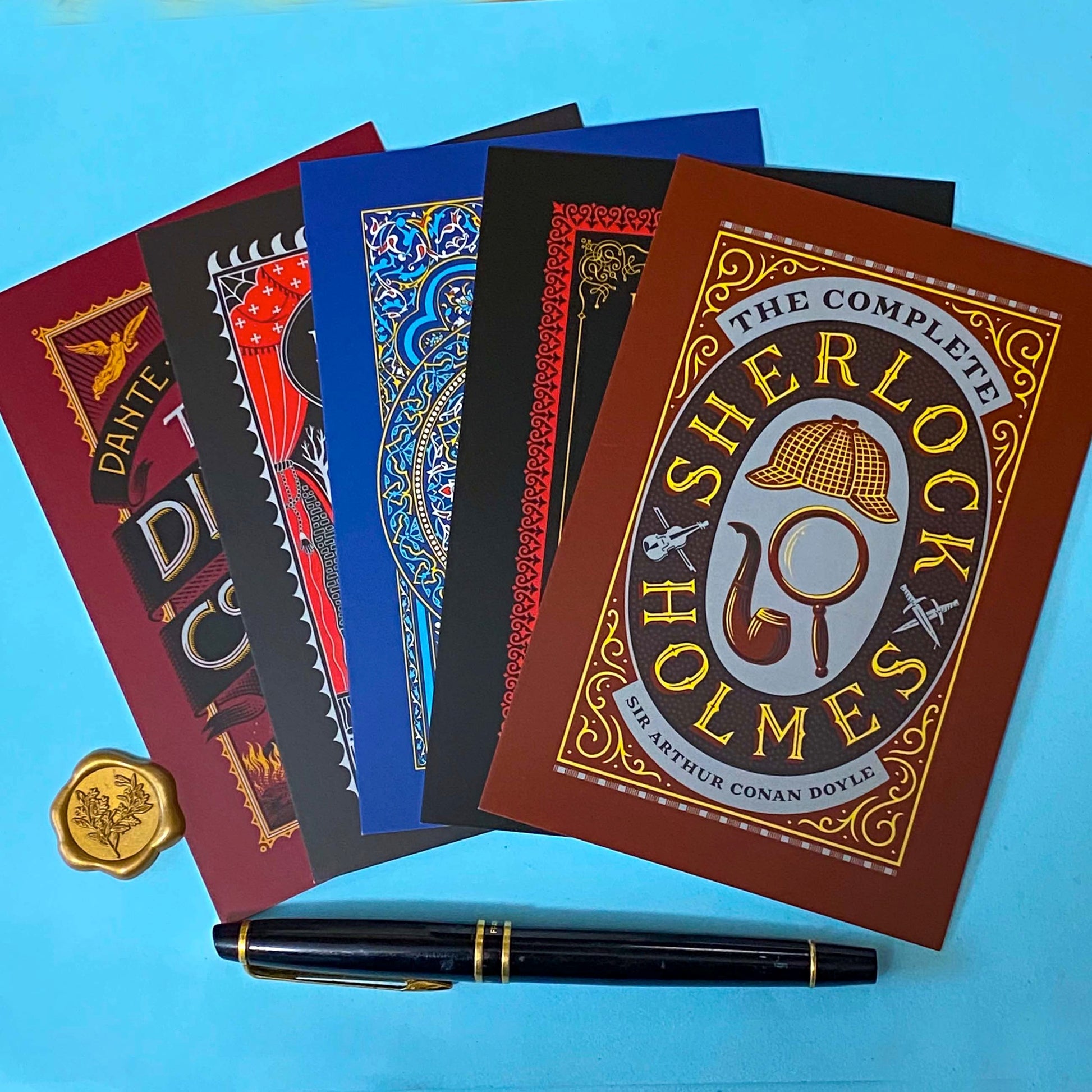 set of 5 vintage literary postcards featuring gothic book covers including dracula, sherlock holmes and edgar allan poe on a blue background