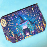 witchy pouch with purple and blue celestial magical design including cauldron, symbols, candles and books.