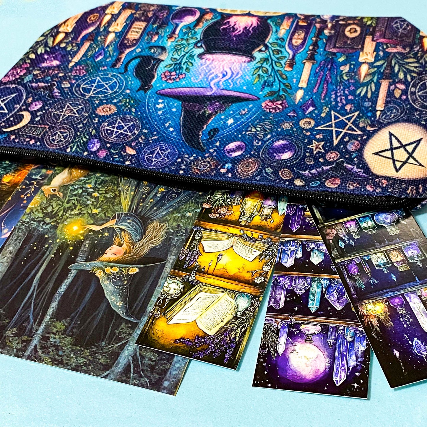 close up of a witch aesthetic canvas pouch with cauldron, candles and celestial symbols in purple and blue. 