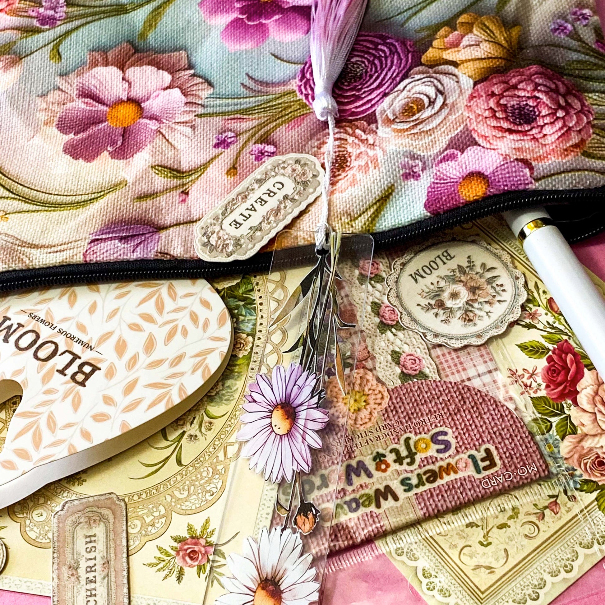 vintage floral letterbox gift set with large flower pouch, pearly white metal pen, daisy tassel acrylic bookmark, floral postcards and vintage decorative journaling stickers on pink background. UK cute gifts and stationery sets.