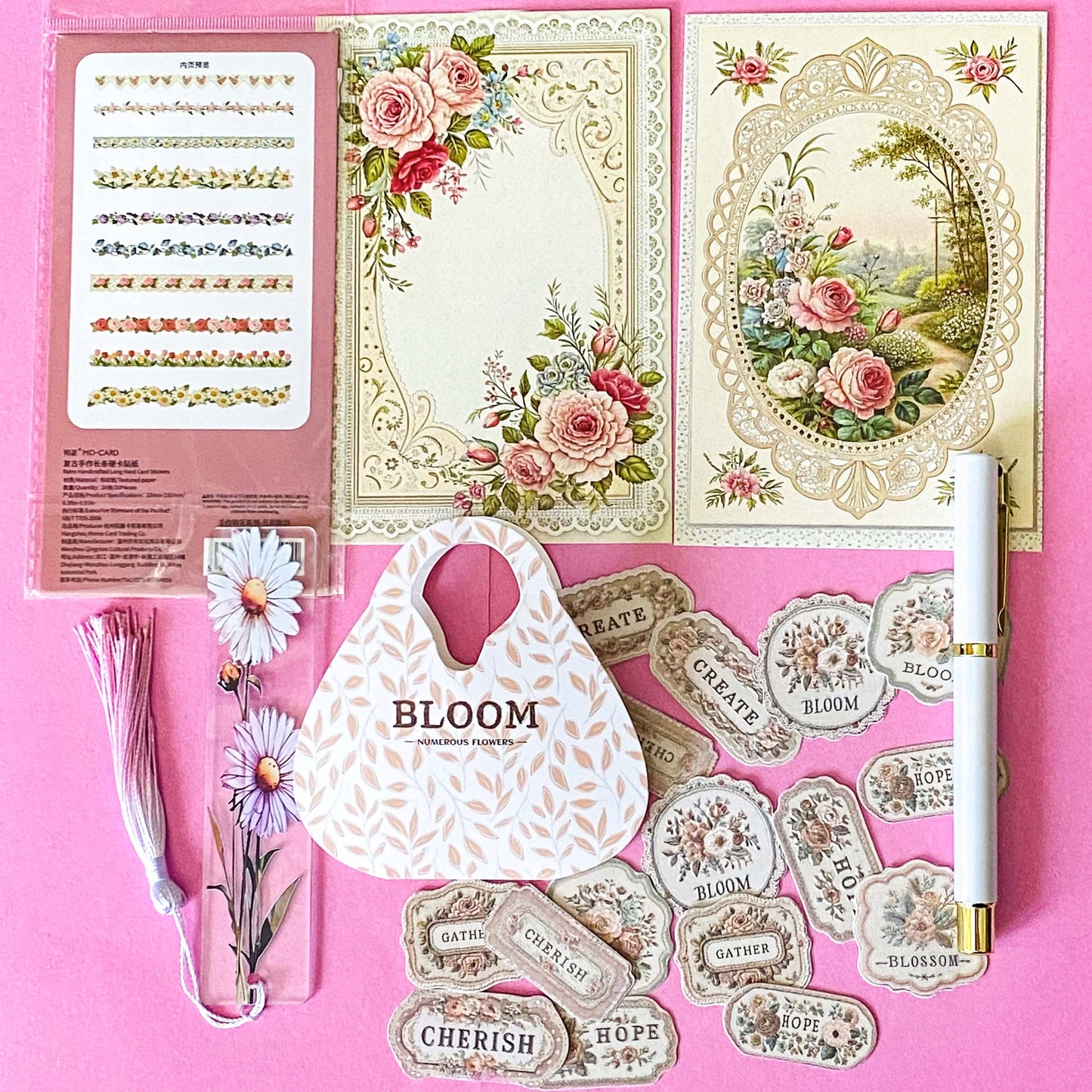 vintage floral letterbox gift set with large flower pouch, pearly white metal pen, daisy tassel acrylic bookmark, floral postcards and vintage decorative journaling stickers on pink background. UK cute gifts and stationery sets.