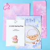 Set of stationery items including a card, stickers, and a small figurine on a blue background. a spring stationery gift