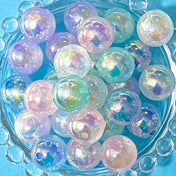 aurora iridescent acrylic 16mm beads with a marble centre on a blue background