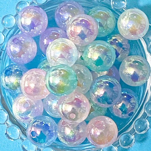 aurora iridescent acrylic 16mm beads with a marble centre on a blue background