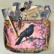 gothic raven themed letterbox gift set with ornate crow fabric pouch, gold metal pen, enamel raven pin brooch, vintage metal bookmark, dark paper stickers and scrapbook papers. Uk gift shop with mystical and witchy gifts.