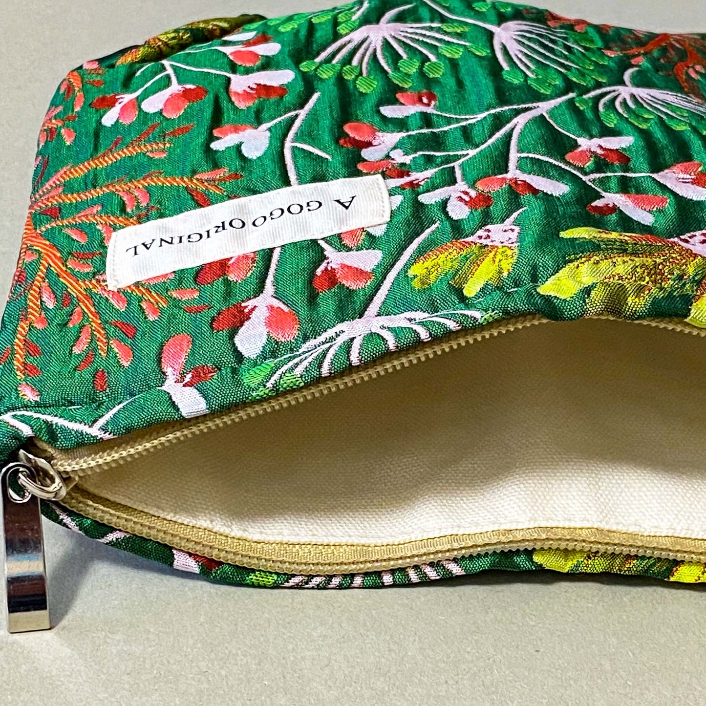 emerald conservatory tapestry pouch featuring a woven satin botanical design in emerald green, coral pink and cream with concealed zip fastening and cream lined interior. Uk luxury letterbox gifts shop. 