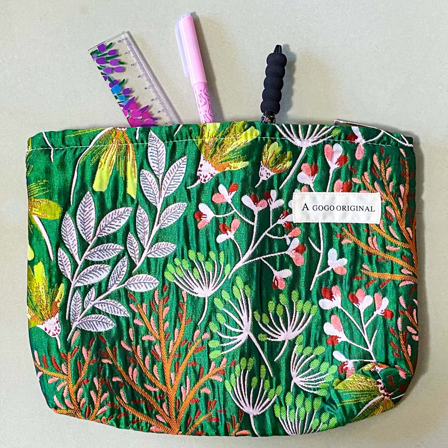 emerald conservatory tapestry pouch featuring a woven satin botanical design in emerald green, coral pink and cream with concealed zip fastening and cream lined interior. Uk luxury letterbox gifts shop. 