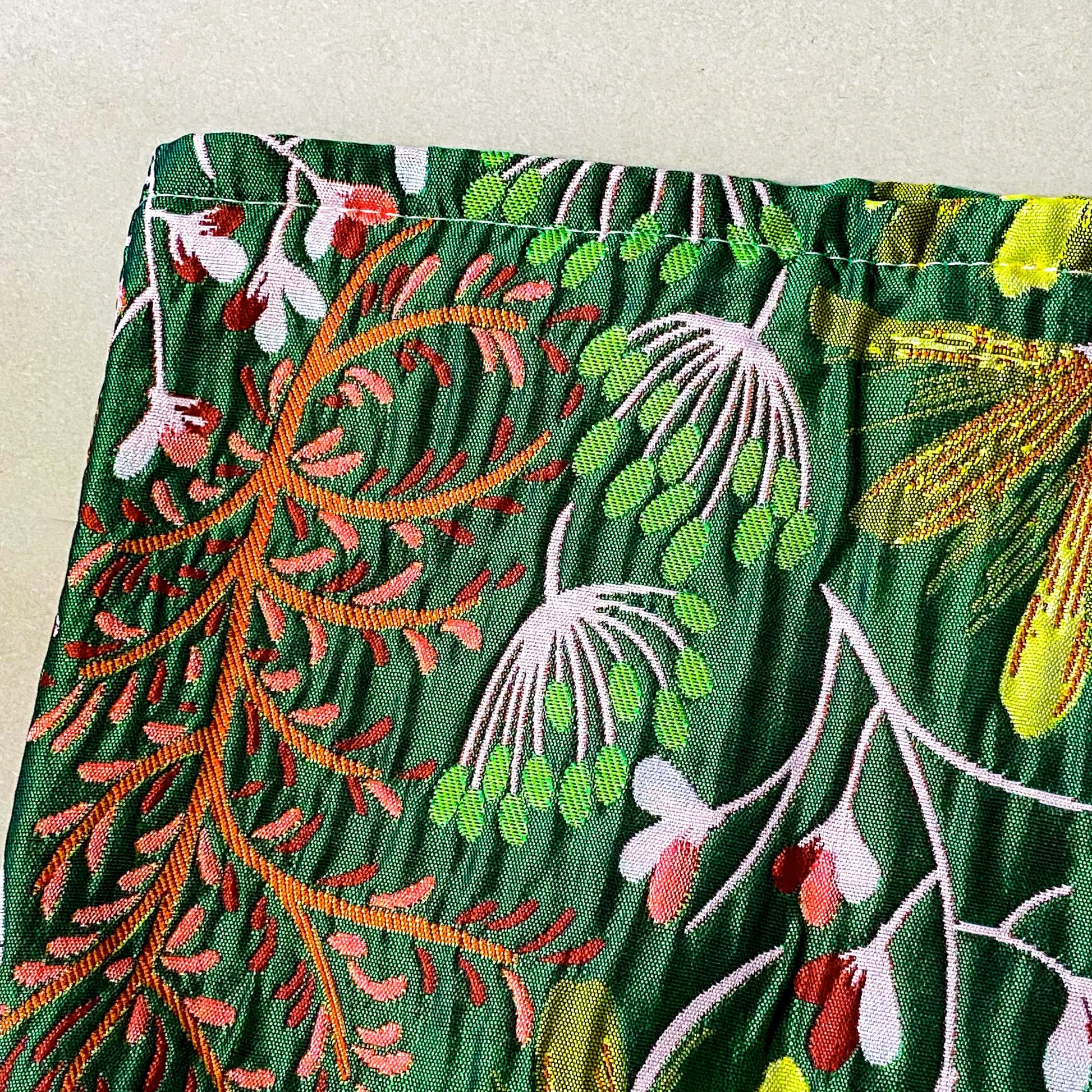 emerald conservatory tapestry pouch featuring a woven satin botanical design in emerald green, coral pink and cream with concealed zip fastening and cream lined interior. Uk luxury letterbox gifts shop. 