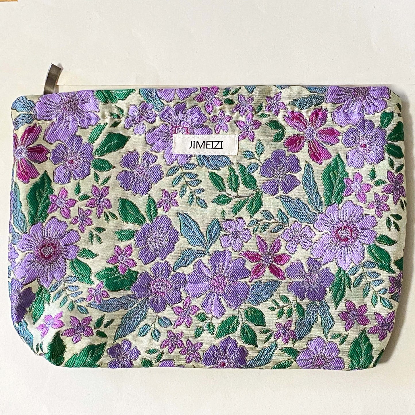 lilac cottage garden tapestry pouch with woven floral fabric in shades of lavender, purple, turquoise and green, fully lined with concealed zip fastening. Uk letterbox gifts. Beautiful quality cosmetic bags.