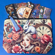 alice inspired letterbox gift set with rabbit canvas pouch, blue tassel acrylic bookmark, blue heart rabbit necklace, enamel bunny brooch, scrapbook papers and miniature white rabbit keepsake tin on deep blue background. uk cute gifts shop.