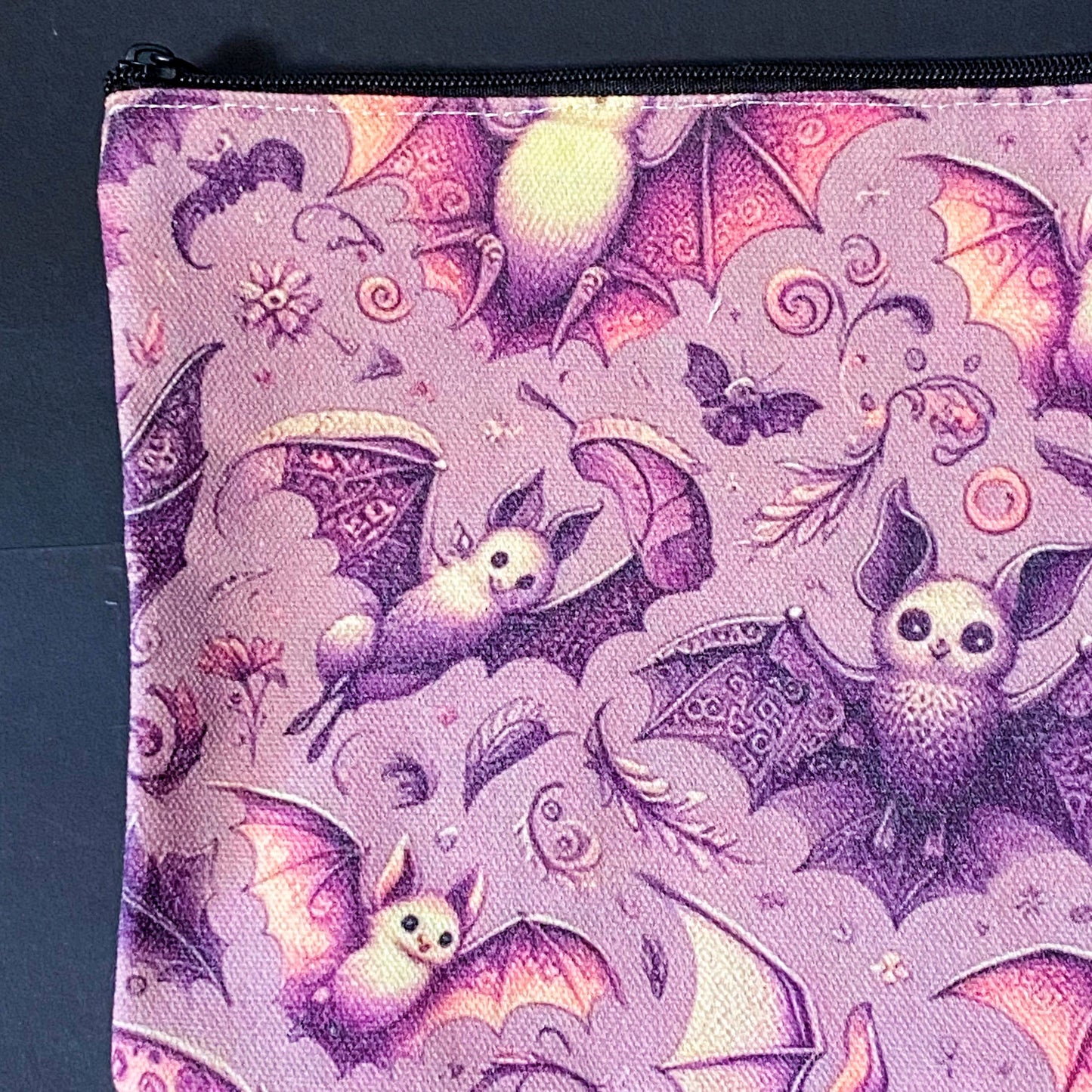 rosewing bats fabric zip pouch featuring whimsical pink and plum purple bats amongst flowers and feathers and moonlit details on a blush pink background. uk cosmetic bags from letterbox gift shop.