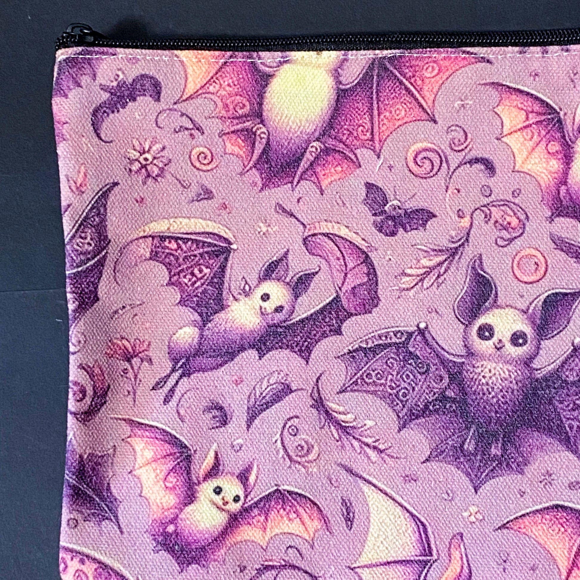 rosewing bats fabric zip pouch featuring whimsical pink and plum purple bats amongst flowers and feathers and moonlit details on a blush pink background. uk cosmetic bags from letterbox gift shop.